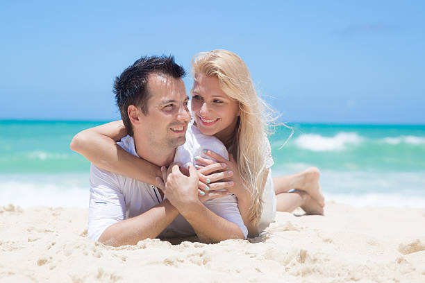 istock Cheerful couple embracing and lying on the beach 510334705