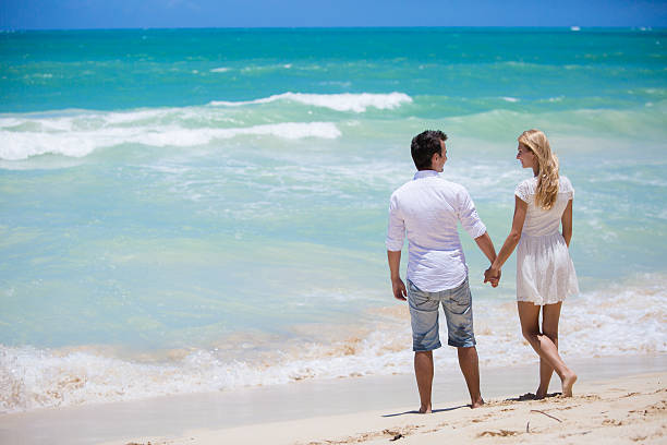 istock Cheerful couple embracing and posing on the beach 510336027