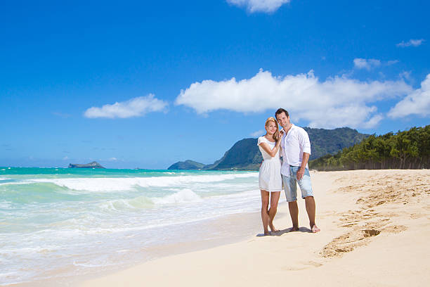 istock Cheerful couple embracing and posing on the beach 510352399