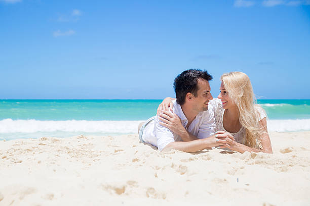 istock Cheerful couple embracing and lying on the beach 510353089