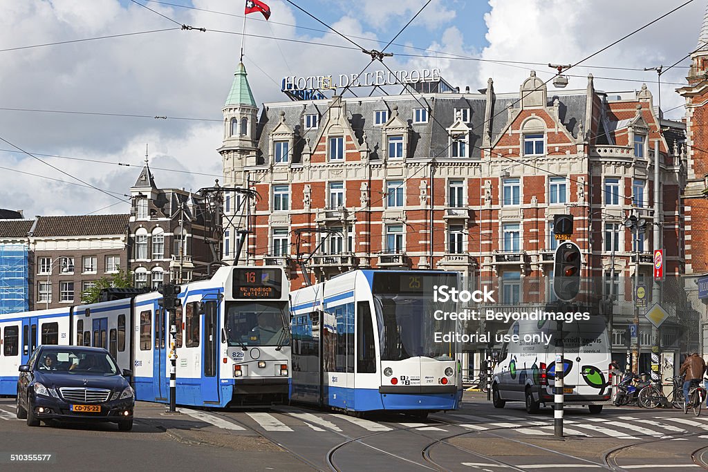 Busy intersection with trams in Amsterdam Amsterdam, The Netherlands - May 15, 2012: A busy intersection in front of the elegant Hotel De L’Europe in Amsterdam, where trams on routes 16 and the now disused Route 25 share the thoroughfare with motor vehicle traffic, cyclists and pedestrians.  Traffic Jam Stock Photo