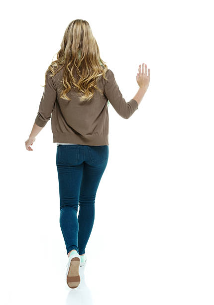 vista posteriore della donna camminare e di - woman with arms raised back view foto e immagini stock