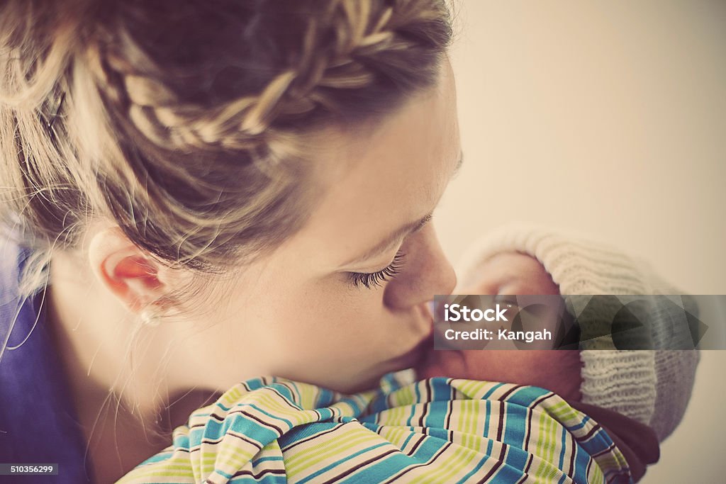 Mother and Newborn Son Mother giving her newborn son a kiss on the lips. 0-11 Months Stock Photo