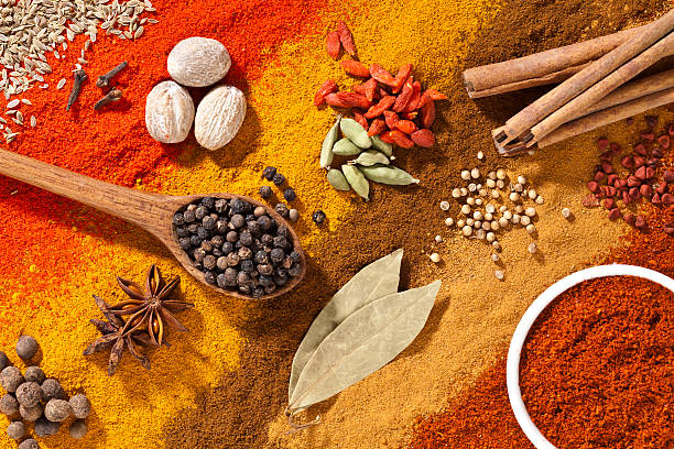 Colorful exotic spices composition shot directly above Multicolored exotic spices composition shot directly above. The background is made of diagonal stripes of multicolored ground spices. Above this background are other spices like nutmeg, cardamom, goji, cinnamon sticks, white pepper, bay leafs, star anise and clove carefully arranged in small groups. A wood spoon filled with black pepper comes from the left while a white bowl filled with paprika is at the bottom-right corner. Very saturated and colorful image taken with DSRL Canon EOS 5D Mk II. allspice stock pictures, royalty-free photos & images