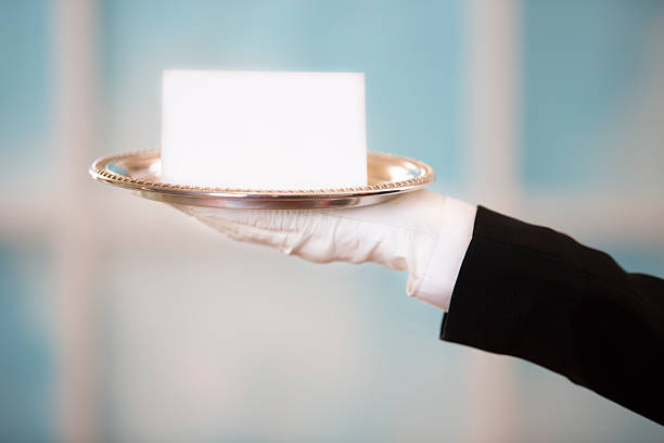 ホワイトバトラーが、ブランク notecard にシルバーの盛り合わせをご賞味ください。 ウィンドウの背景。 - upper class butler high society serving tray ストックフォトと画像