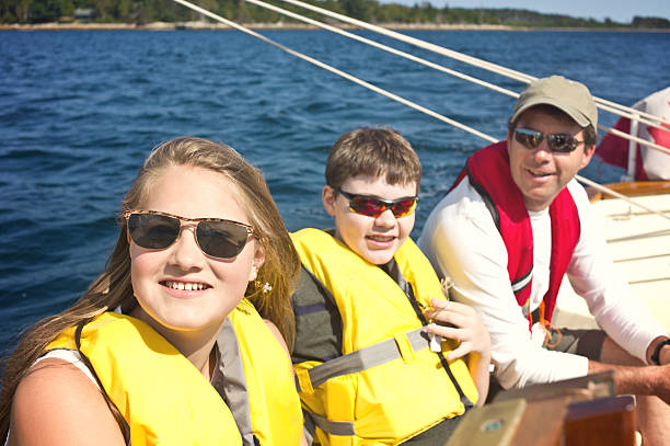 père et de jeunes enfants à voile sur la baie de mahone, nouvelle-écosse - mahone bay photos et images de collection