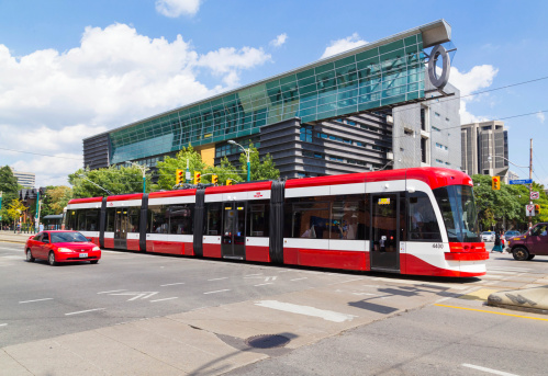 Toronto, Canada - September 3, 2014: A view of the new Toronto Street Cars during the day. Passengers can be seen on the vehicle and on the street