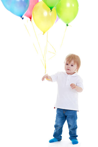 istock little boy holding balloons on a white background. 510376571