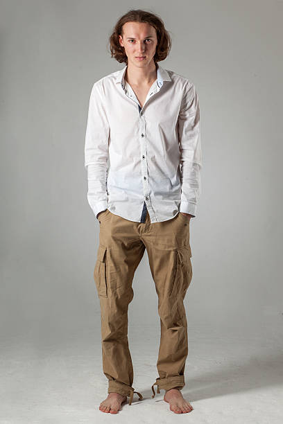 istock young man stay with hands in pockets on gray background 510382712