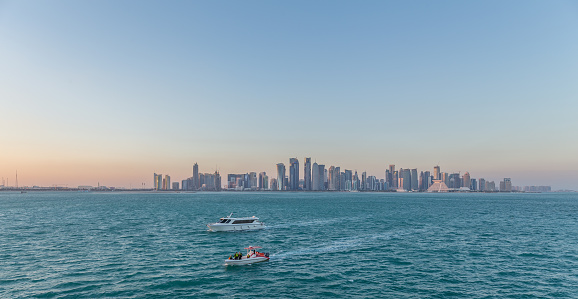 Doha, Qatar - January 30, 2016: Sailing boats in front of doha skyline in the city center of Doha, the capital of the Arabian Gulf country Qatar on January 30, 2016.