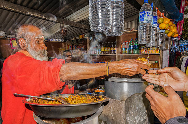 Old man with his daughter in a roadside stall Kodaikanal, Inida - December 26, 2015: An old man with his daughter selling hot corn and masala chickpeas in a stall on the roadside near the Kodaikanal Lake. kodaikanal photos stock pictures, royalty-free photos & images