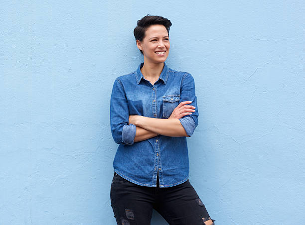 istock Cool young woman standing against blue background 510388292
