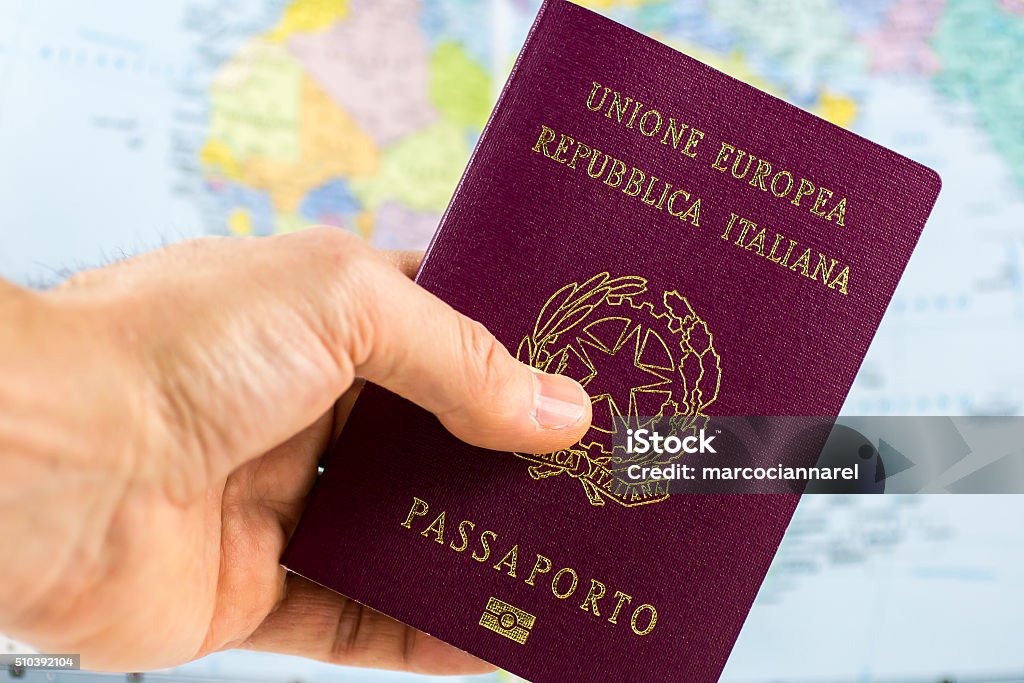 hand holds an Italian Passport hand holds an Italian passport with a blurred map in the background Passport Stock Photo