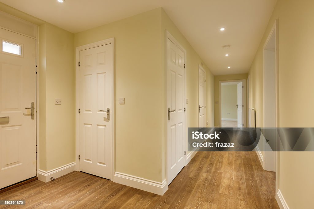 Home Reception Hall Reception Hall within new property with several doors and wooden flooring Corridor Stock Photo