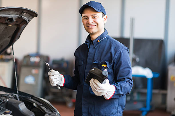 istock Auto mechanic putting oil in a car engine 510395072