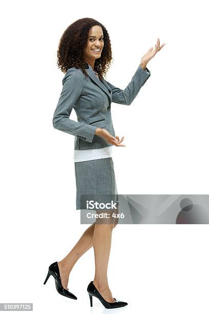 Cheerful Businesswoman Walking Presenting Stock Photo - Download Image Now - Presentation - Speech, Walking, 20-29 Years