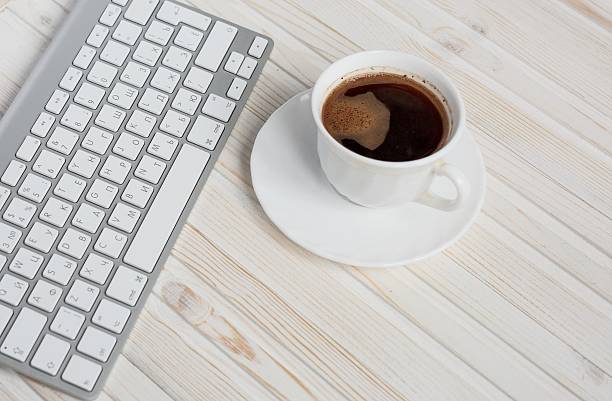 istock White laptop with coffee cup  on old wooden table 510397590