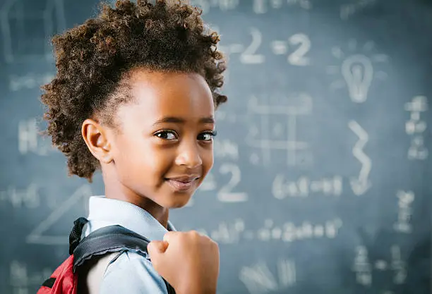 Photo of Cute little African school girl in classroom