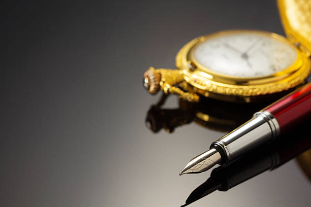 istock pocket watch and ink pen on black 510398432