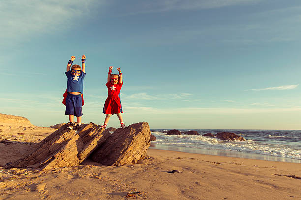 chłopiec i dziewczynka ubrany jak superbohaterowie :  i jedni w kalifornii plaża - superhero child partnership teamwork zdjęcia i obrazy z banku zdjęć