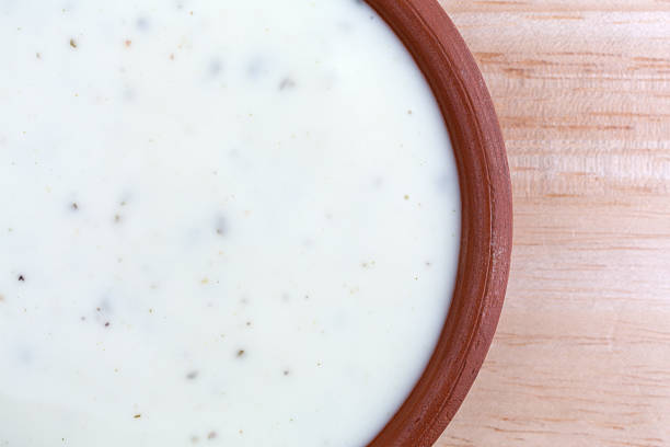 Bowl of ranch dressing on a wood table top Top close view of a small bowl of ranch dressing on a wood table top illuminated with natural light. ranch dressing stock pictures, royalty-free photos & images