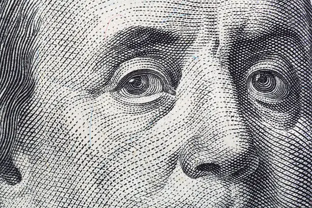 A very close view of the portrait of Benjamin Franklin on a hundred dollar American bill.
