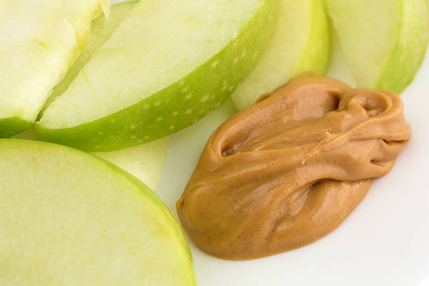 istock Green apple slices on dish with peanut butter close view 510401232