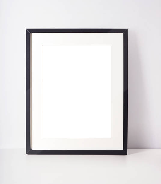 istock Black picture frame leaning on white wall 510406256