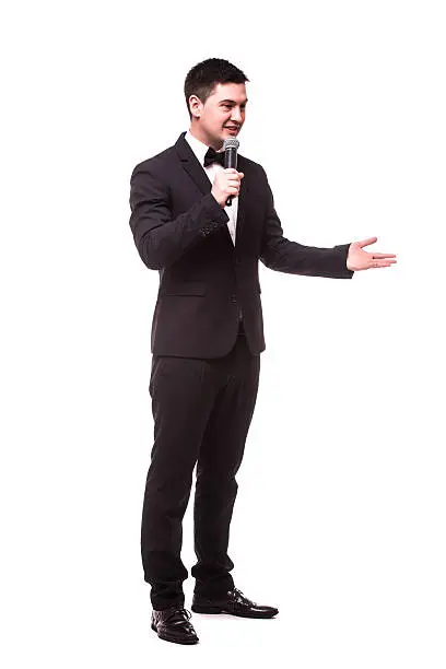 Young Showman present invisible product or advertising  with microphone against white background.Showman concept.