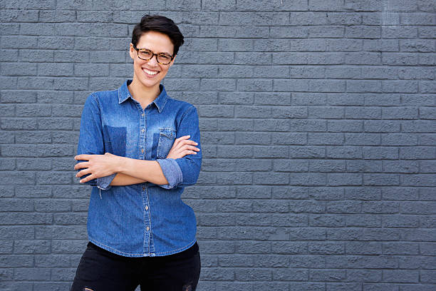 istock Smiling young woman posing with glasses against gray background 510410930