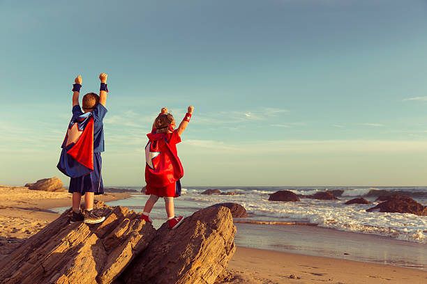 jungen und mädchen gekleidet wie superhelden auf california strand - beach ideas stock-fotos und bilder