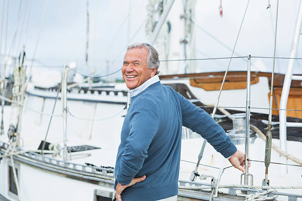 istock Senior man at marina, standing beside his boat 510414162