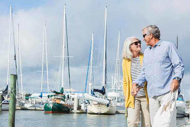 istock Happy senior couple walking along harbor holding hands 510414364