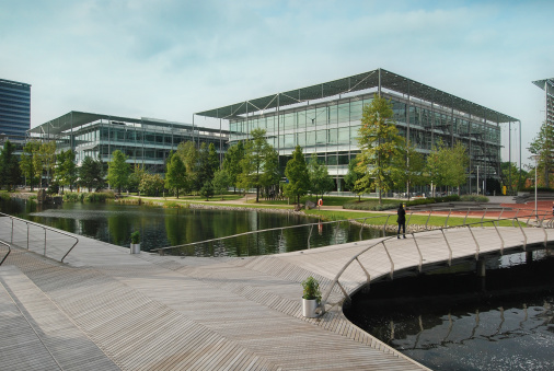 Chiswick, London, England - September 18, 2009: Modern, high quality business park in Chiswick, London. Two large buildings are visible, standing along a pond. In front is a footbridge.