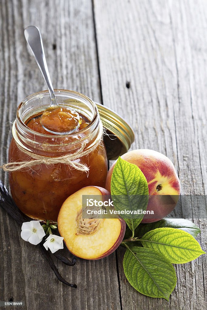 Vanilla peach jam in a bowl Vanilla peach jam in a bowl with vanilla sticks and fresh peaches Backgrounds Stock Photo