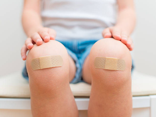 Child knee with an adhesive bandage. stock photo