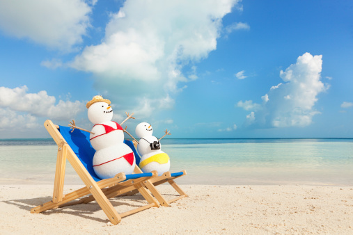 Subject: A snowman couple scantily dressed in bikini and swimming trunks, sunning seaside on beach chairs, enjoying themselves on a winter tropical vacation.