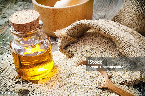 Sesame Seeds In Sack And Bottle Of Oil On Table Stock Photo - Download Image Now - Sesame Oil, Sesame, Cooking Oil