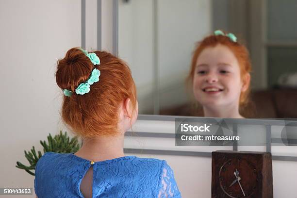 Girl With Red Hair In Bun Looking In Mirror Posing Stock Photo - Download Image Now