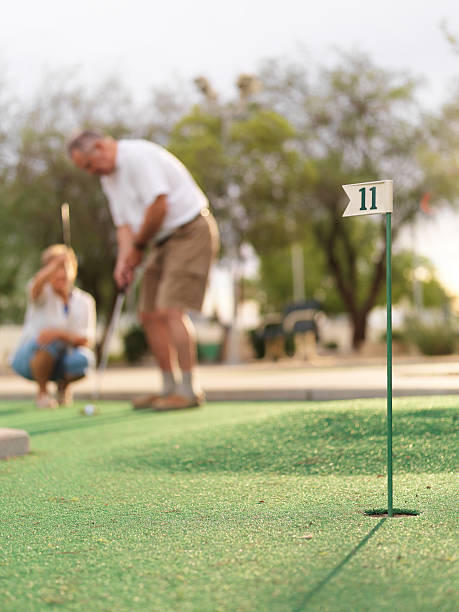 casal sênior jogando minigolfe - senior couple golf retirement action - fotografias e filmes do acervo