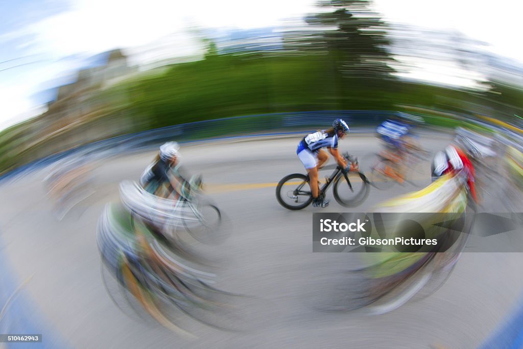 Women's Road Bicycle Race A group of female bicycle racers ride together in a pack during a criterium road race. Activity Stock Photo