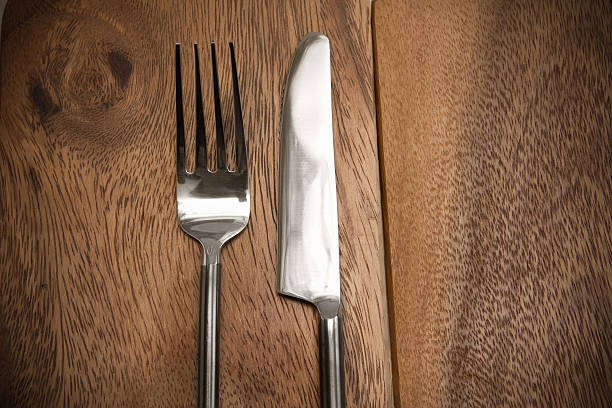 istock Silver Knife and fork over wooden table 510463645
