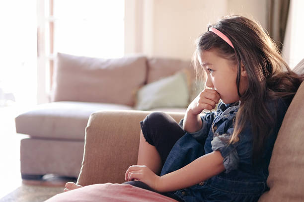 Jolie petite fille en regardant la télévision sur le canapé - Photo