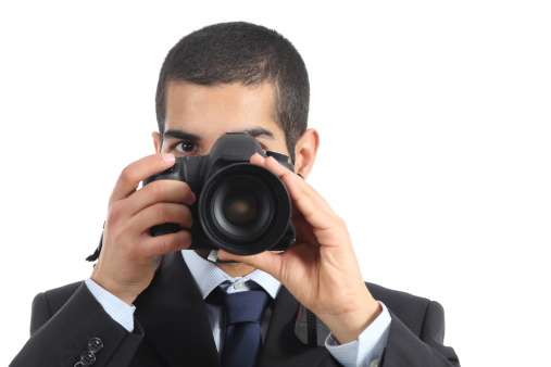 Front view of a professional photographer taking a photograph isolated on a white background