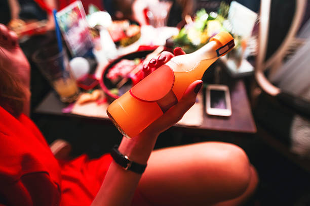 Woman holding a bottle of alcohol Woman holding a bottle of alcohol. On bar background girls getting ready to go out stock pictures, royalty-free photos & images