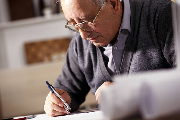 istock Senior architect working on construction blueprint in office 510476354