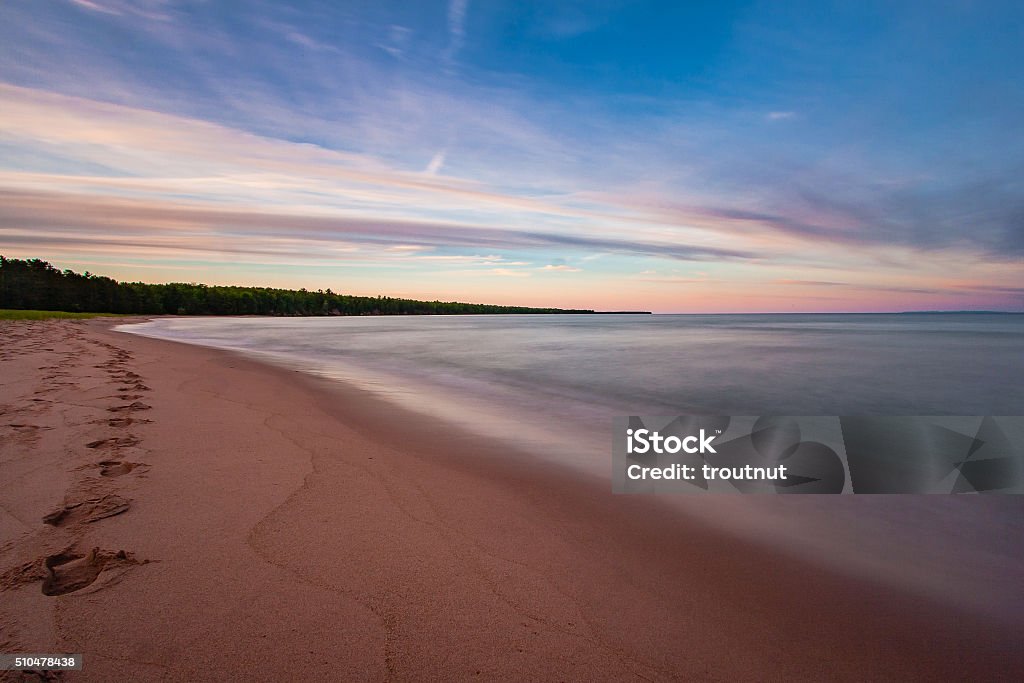 Sunset over Lake Superior A long exposure captures the smoothness of the waves at the beach on Madeline Island in the Apostle Islands in Lake Superior Wisconsin Stock Photo