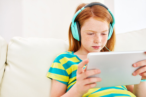 Shot of a little girl using a digital tablet with headphones at homehttp://195.154.178.81/DATA/i_collage/pu/shoots/806357.jpg