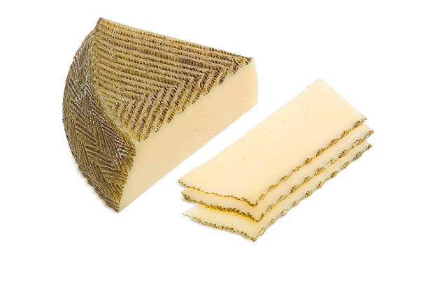 istock Piece and several slices of Spanish cheese on light background 510486898