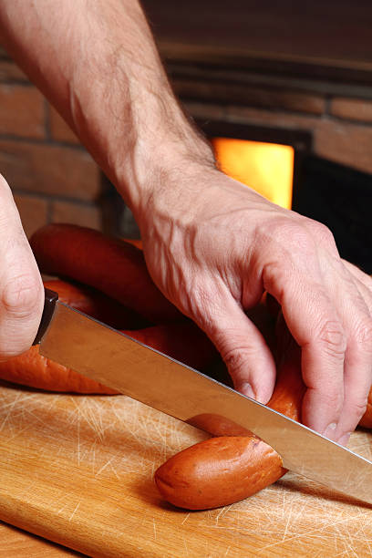 istock Chef cutting sausages at wood fired oven background 510491072